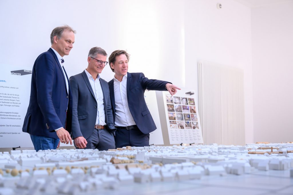 Oberbürgermeister Tilman Fuchs (M.) ließ sich bei der Eröffnung der Ausstellung „Münster Modell – 20 Jahre Forum für Baukultur“ das Münster-Modell vom Vorsitzenden des Vereins Münster Modell e.V., Stefan Rethfeld (r.), und Christopher Festersen, Leiter des Stadtplanungsamtes und Vorstandsmitglied, zeigen. - Foto: Stadt Münster / Michael Möller